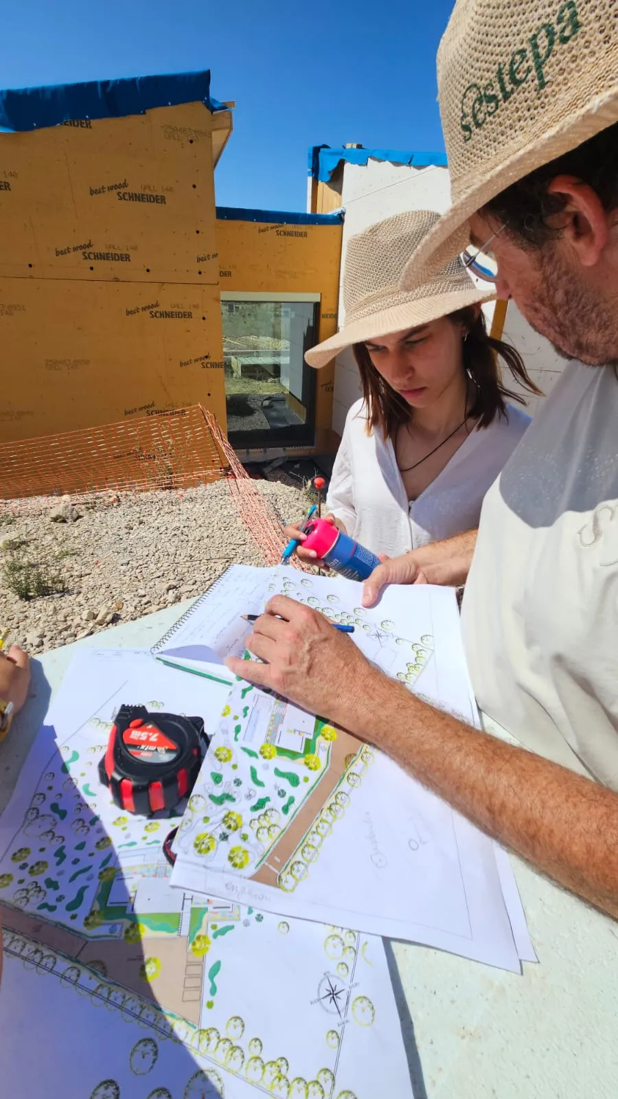 Pedro Campaner sketching a hand-drawn colour masterplan on site while Sofia Grimaux marks out the ground